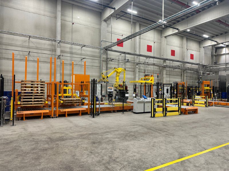 Palletiseerinstallatie om lege vaten op pallets te plaatsen en te omsnoeren.